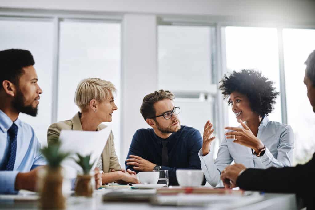 A group of businesspeople working together in a meeting, looking happy