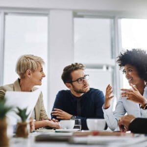 A group of businesspeople working together in a meeting, looking happy