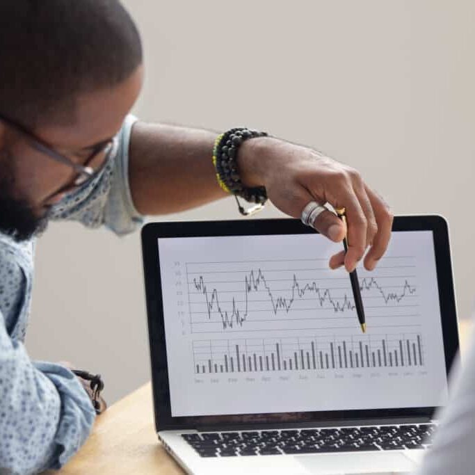 Focused man showing data report on laptop screen